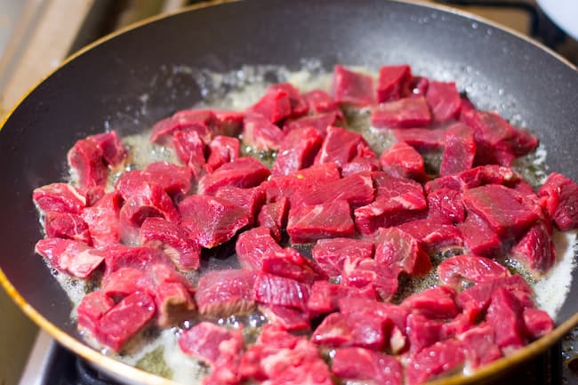 Chopped pieces of beef in frying pan
