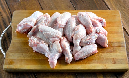 Raw chicken pieces on cutting board Raw chicken for homemade puppy food