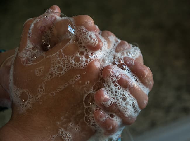 Hands being washed and covered in soap suds Hands being washed and covered in soap suds
